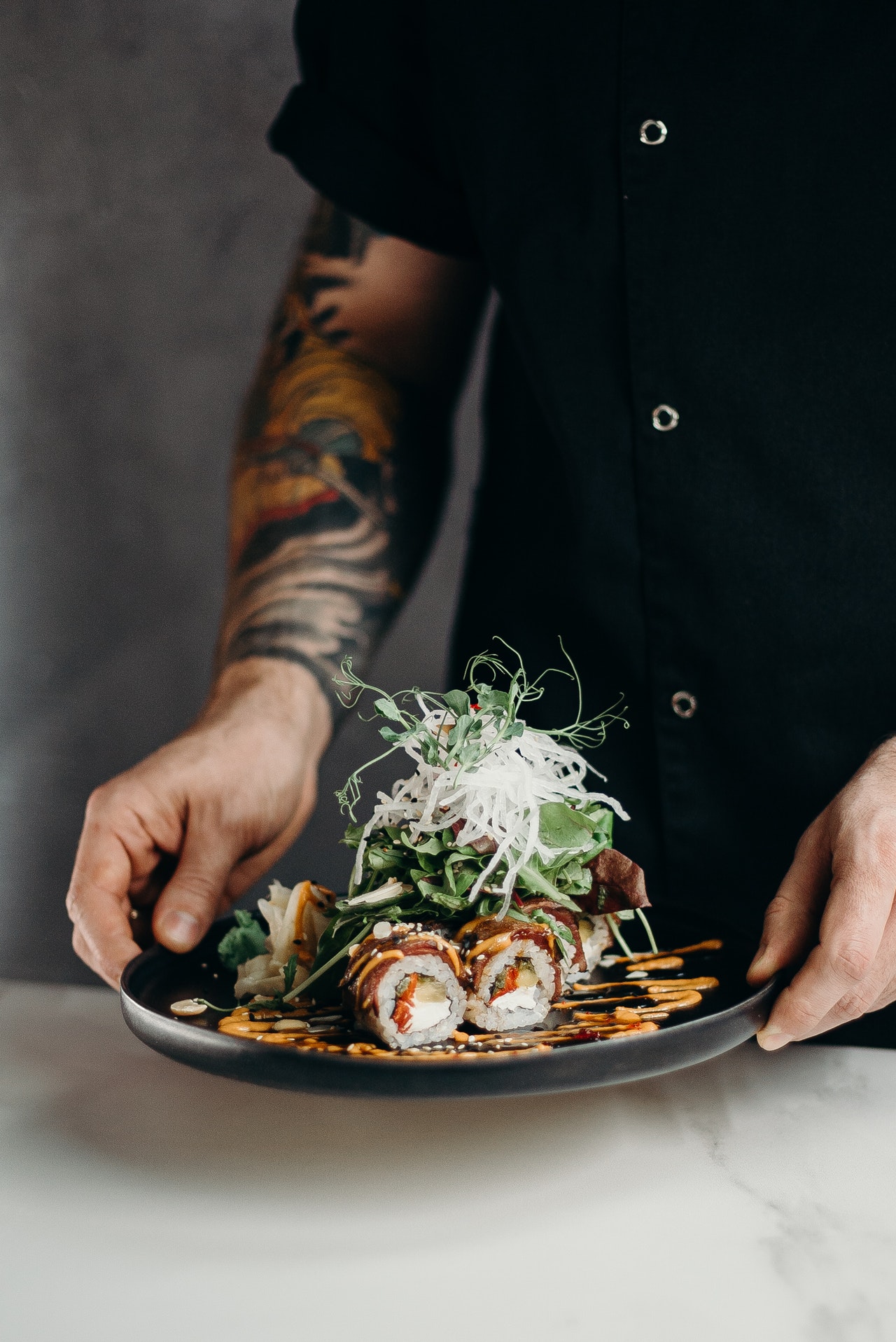 person-holding-a-plate-of-sushi-rolls-3304057.jpg